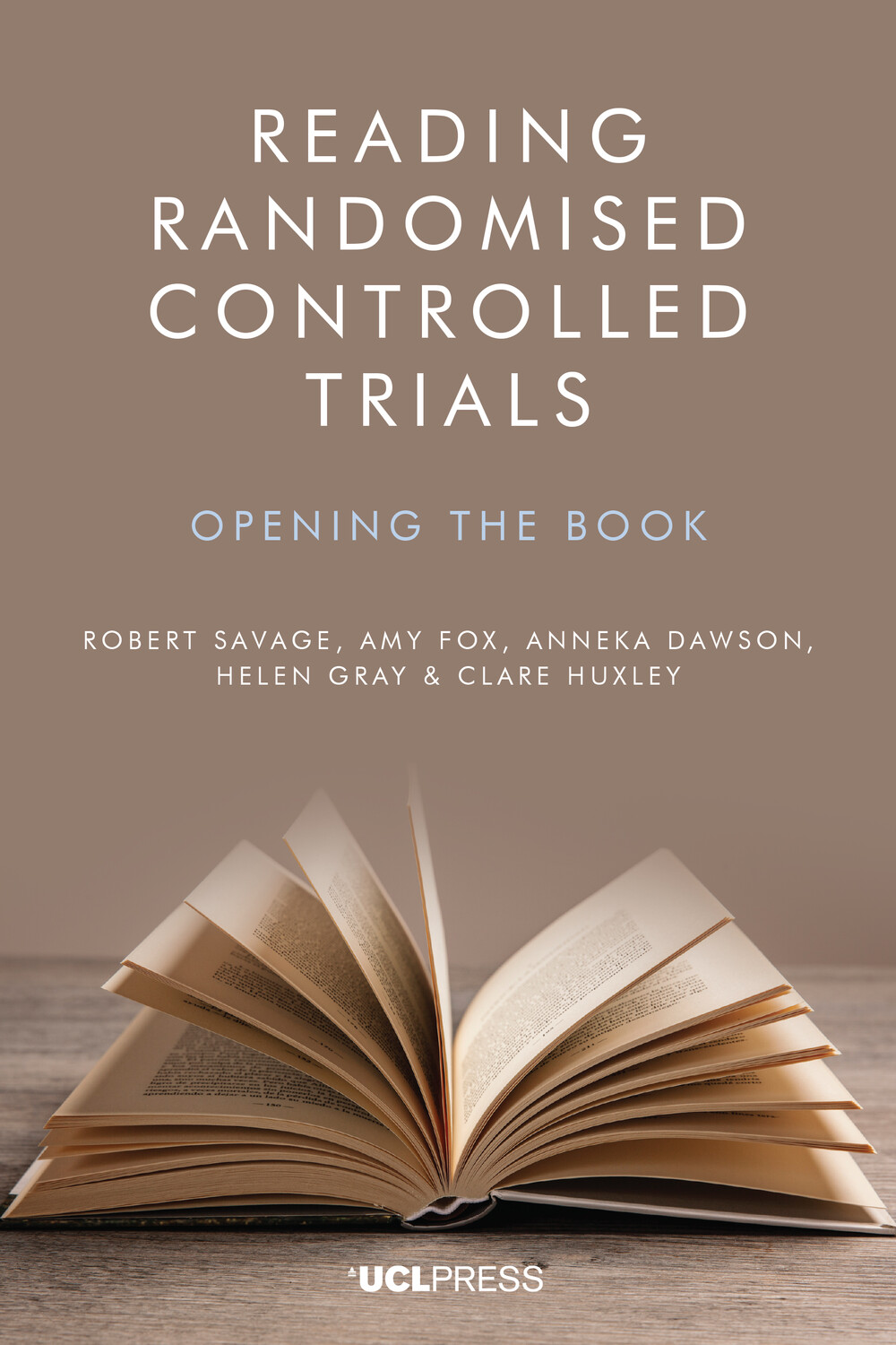 Book cover titled 'Reading Randomised Controlled Trials: Opening the Book.' by Robert Savage, Amy Fox, Anneka Dawson, Helen Gray, and Clare Huxley. The cover displays an open book with pages spread out on a wooden surface, set against a plain backdrop.