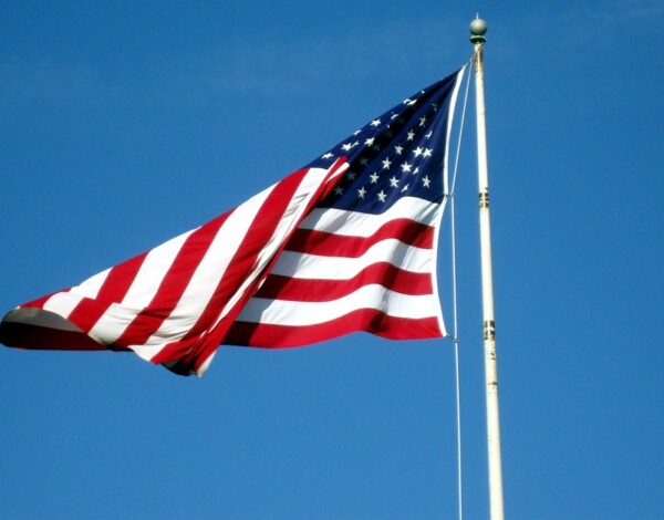 US flag flying against a clear blue sky.