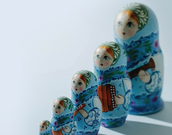 A set of four blue matryoshka dolls with floral patterns arranged by size.