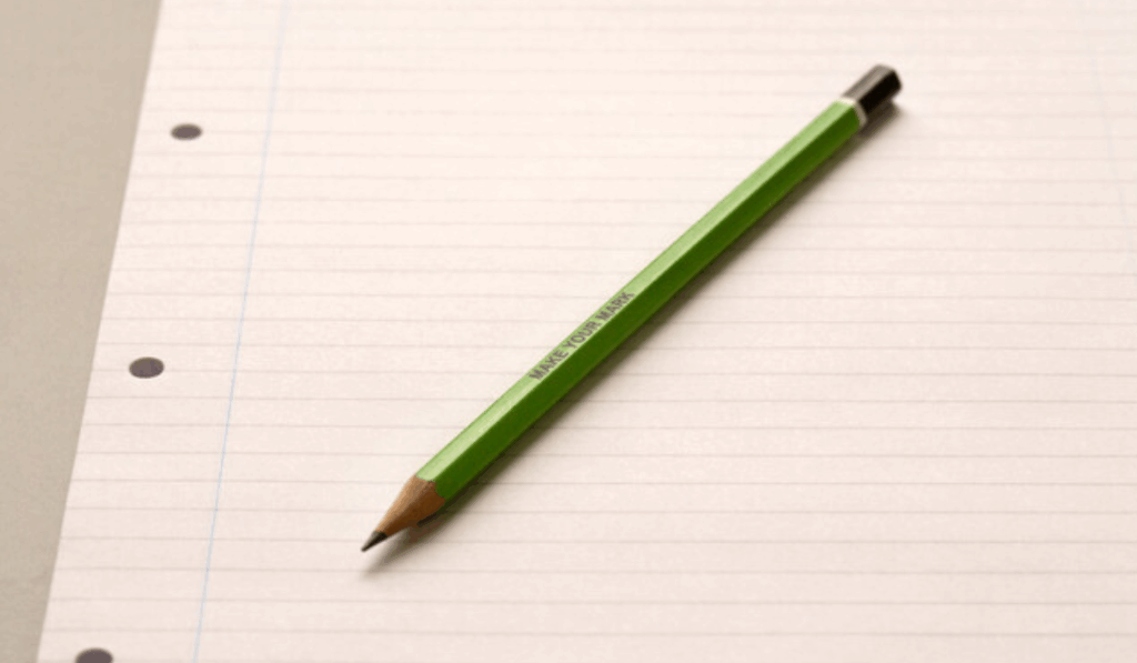 A green pencil on lined paper with "MAKE YOUR MARK" printed on it.
