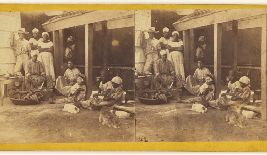 A group of enslaved Black men and women, in the kitchen of a barracoon.