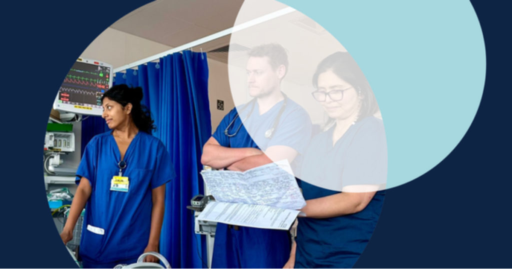 Healthcare workers in a hospital room reviewing patient charts.