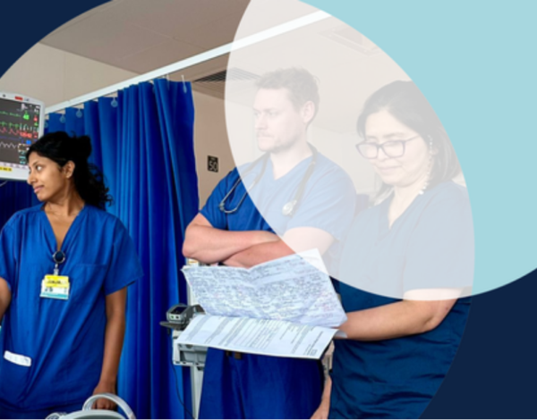 Healthcare workers in a hospital room reviewing patient charts.