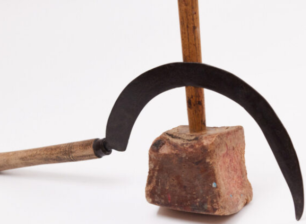A sickle with a curved blade and wooden handle leans against a hammer with a wooden handle and a brick head, as featured on the cover of Russian Pendulum.