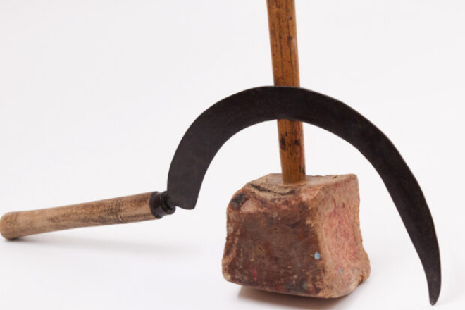 A sickle with a curved blade and wooden handle leans against a hammer with a wooden handle and a brick head, as featured on the cover of Russian Pendulum.